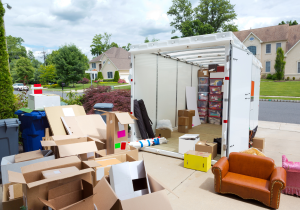 moving storage container with boxes and furniture in driveway